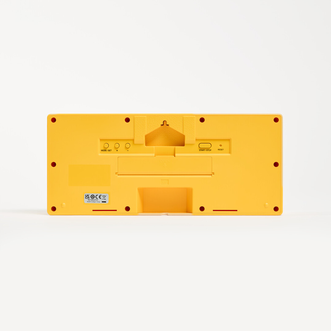 Back of a yellow mantel clock showing a compartment for AA batteries