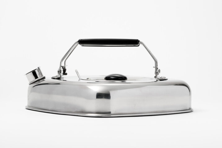 A flat square silver stove kettle with black folding handles