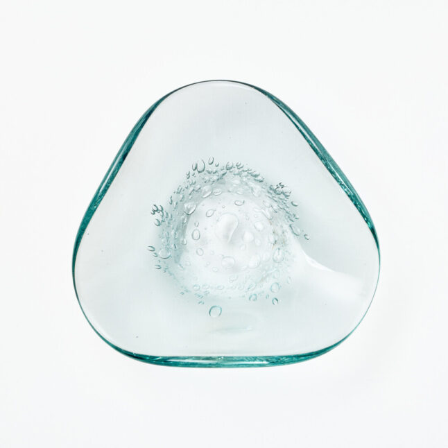 A small triangle shaped glass plate with small bubble details in the middle