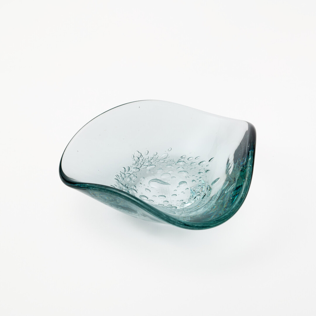 A small triangle shaped glass plate with small bubble details in the middle