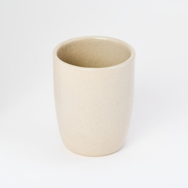A small, tall, ceramic, white yunomi, a cup for drinking tea