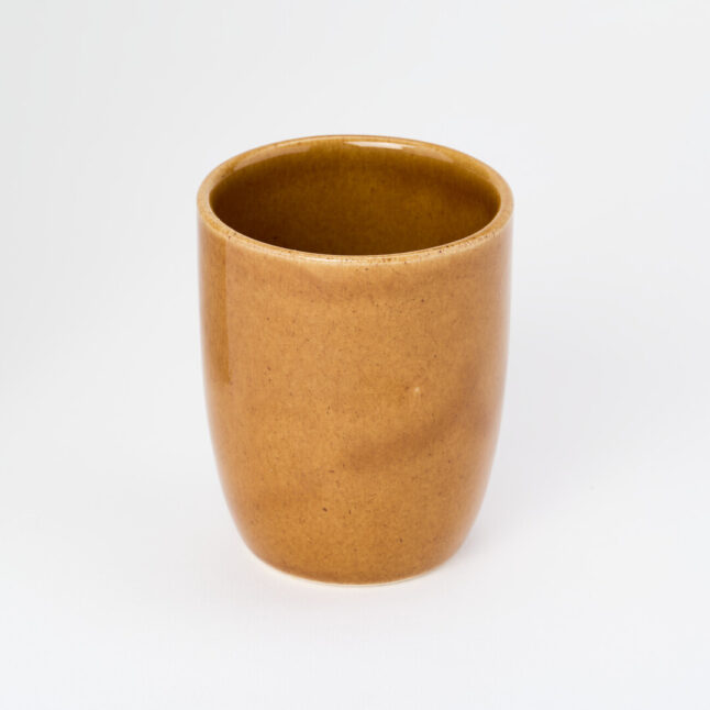 A small, tall, ceramic, light brown yunomi, a cup for drinking tea