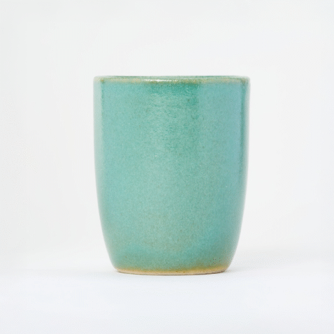 A small, tall, ceramic, light turquoise yunomi, a cup for drinking tea