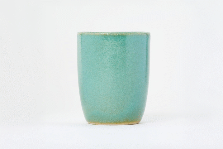A small, tall, ceramic, light turquoise yunomi, a cup for drinking tea