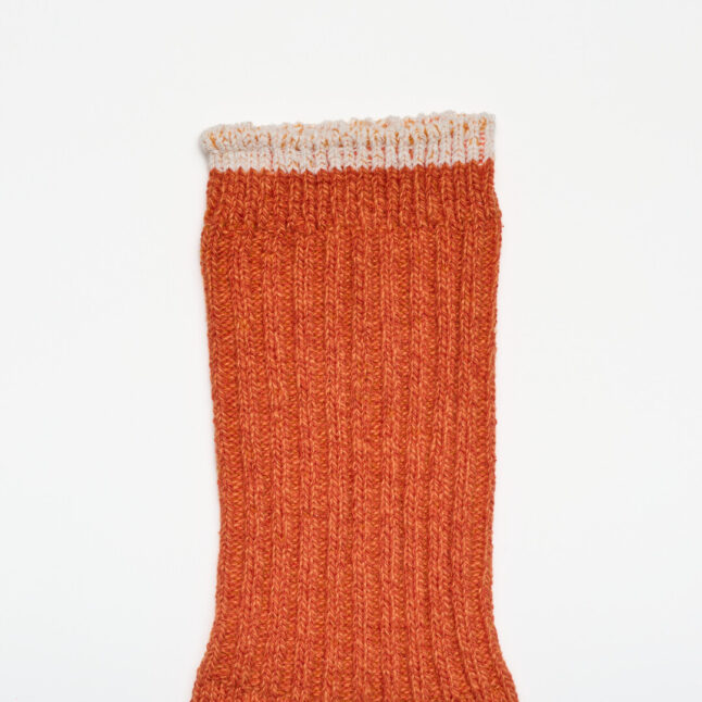 An orange sock with cream edge