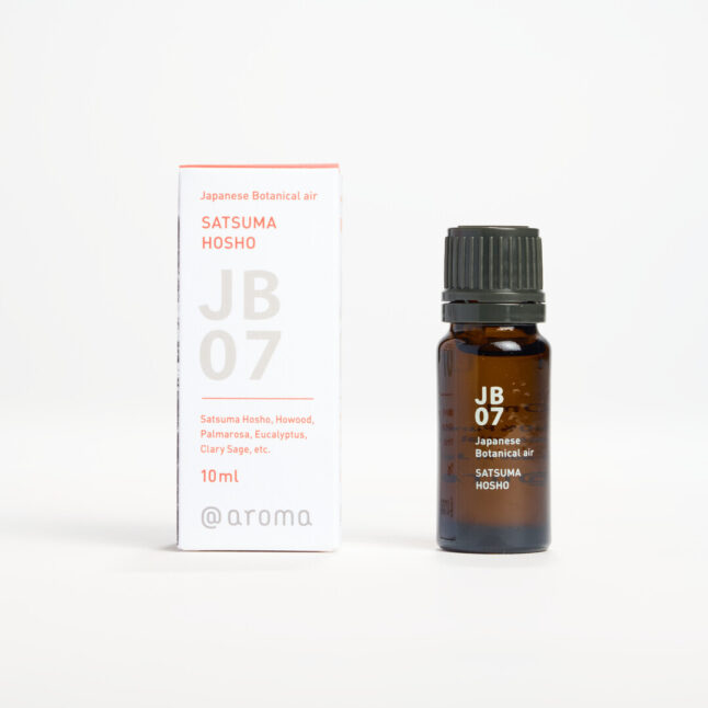 Small bottle of essential oil with white writing of JB07 Japanese Botanical Air Satsuma Hosho next to a small white box with orange and grey writing Satsuma Hosho JB07 10ml @aroma