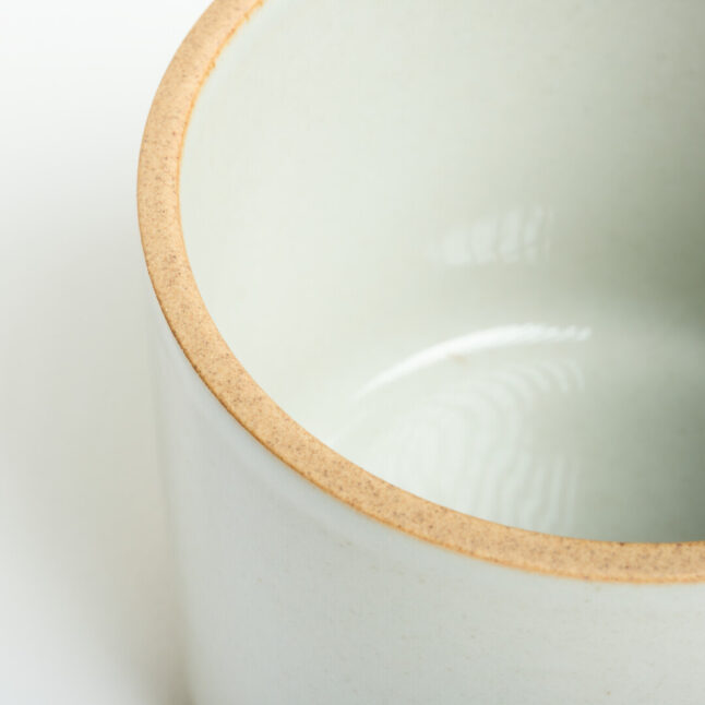 A light grey mug with a unglazed edge which is a light beige