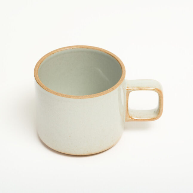 A small light grey mug with unglazed details on the handle and foot