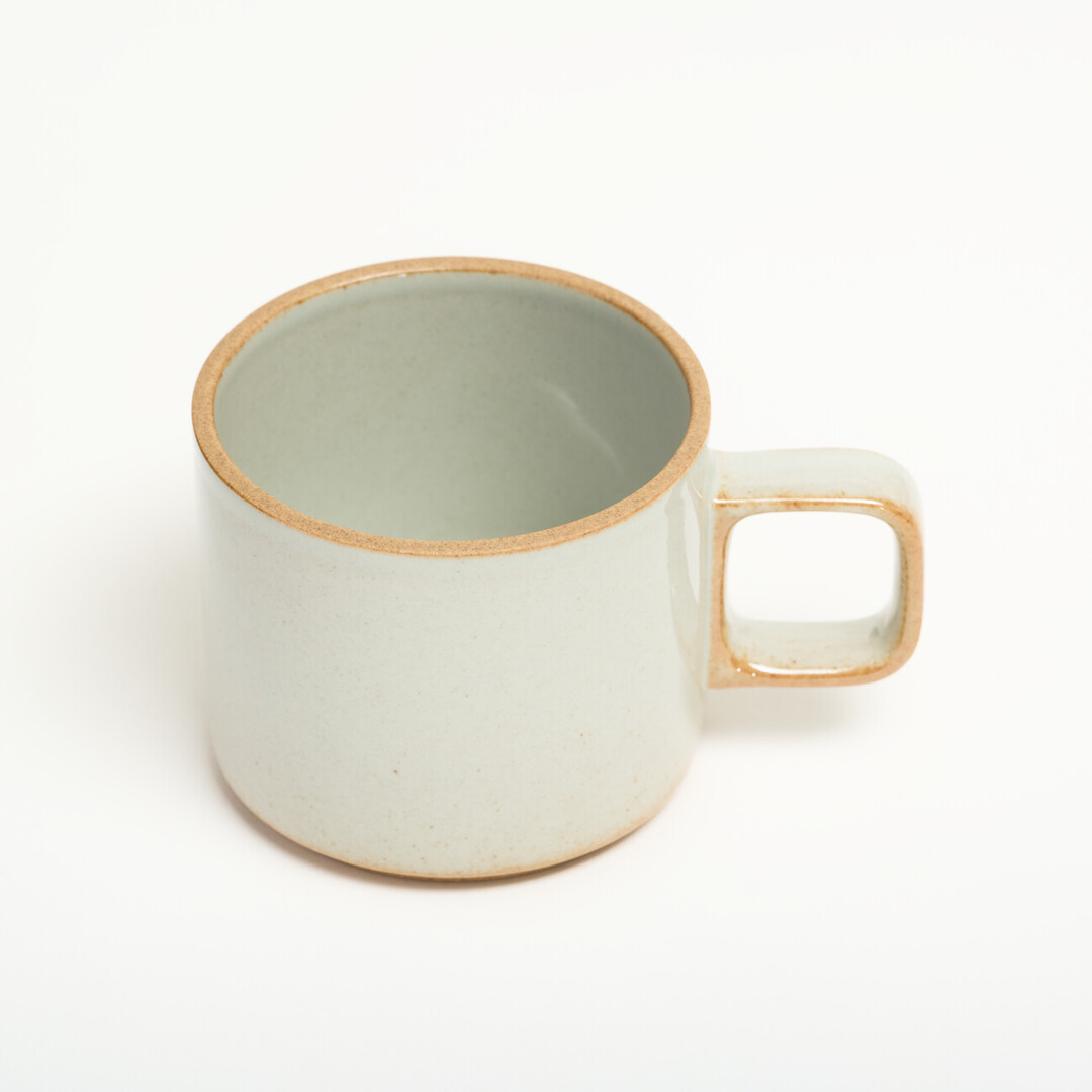 A small light grey mug with unglazed details on the handle and foot