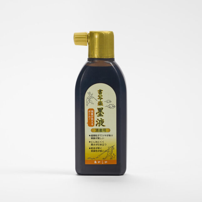 A bottle of ink for calligraphy with a gold lid and a gold label