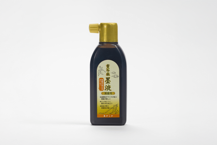 A bottle of ink for calligraphy with a gold lid and a gold label
