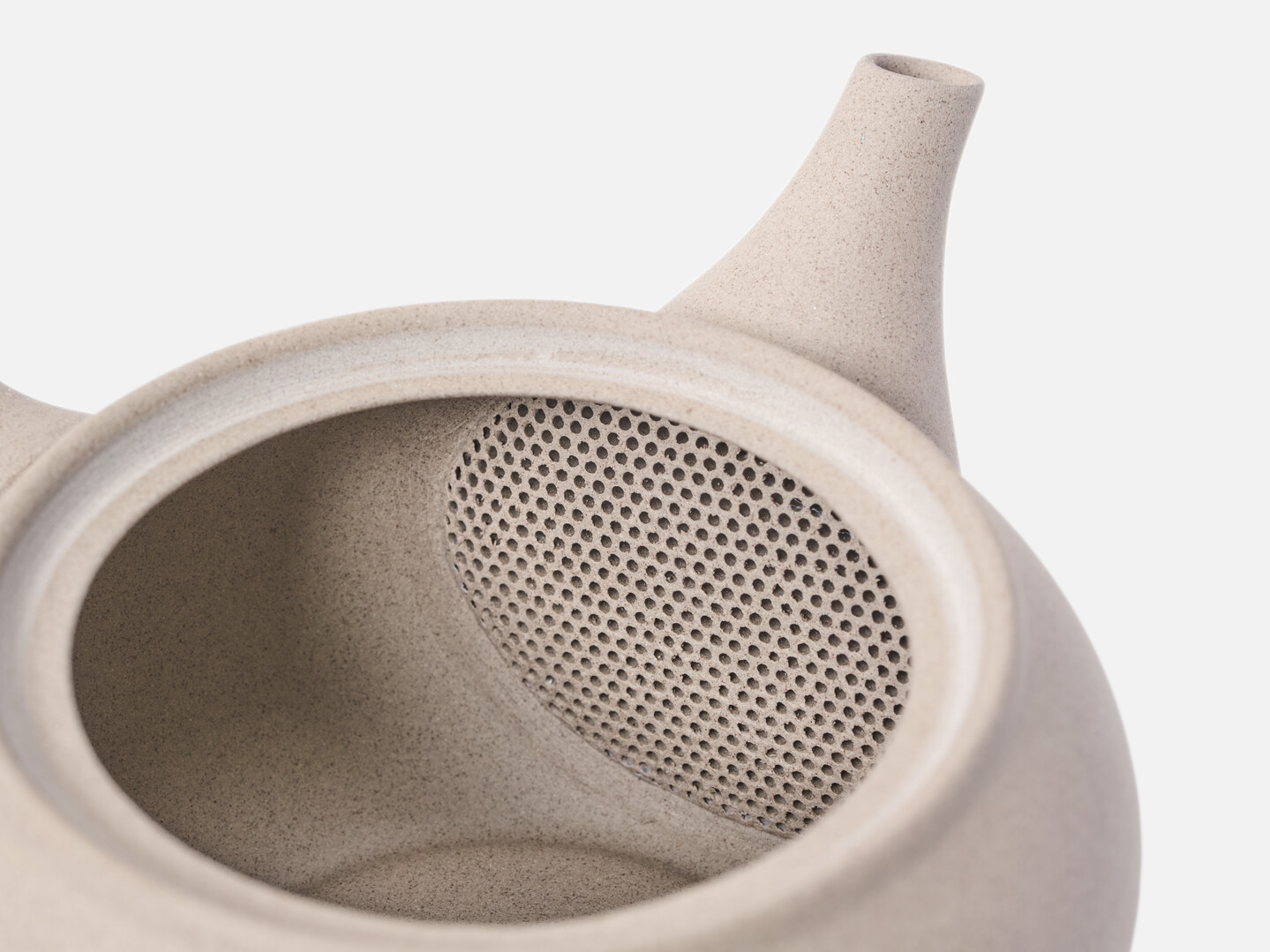 A built in filter inside the beige tea pot for green tea