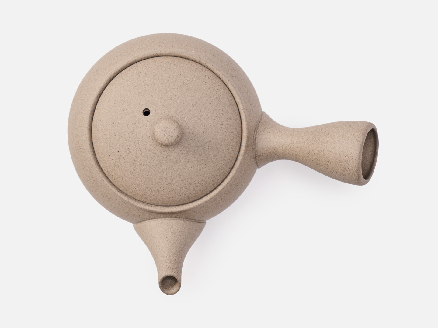 A beige rounded teapot for green tea with a handle on the side