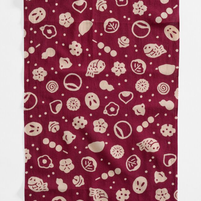 A reddish brown tenugui with beige pictograms of Japanese confectionery