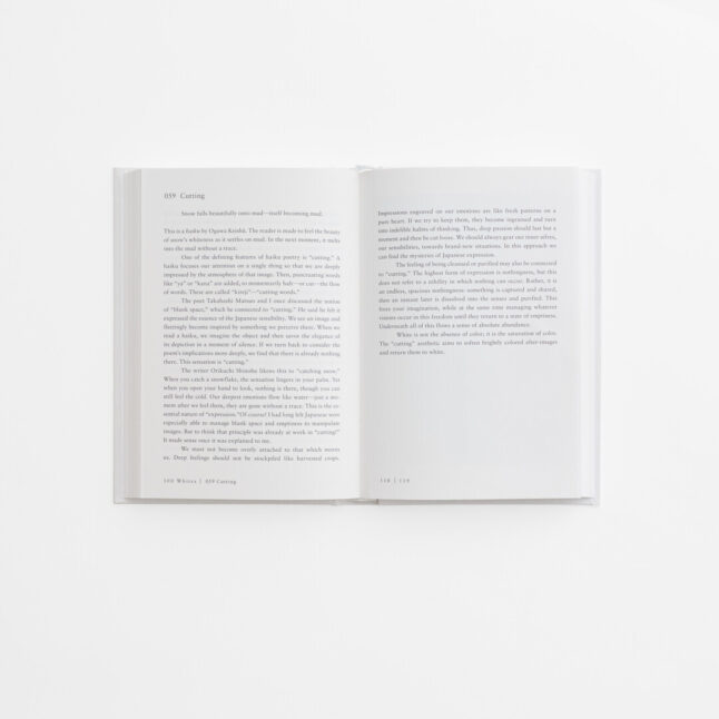 An open spread of the book 100 Whites by Hara Kenya with white pages and black writing