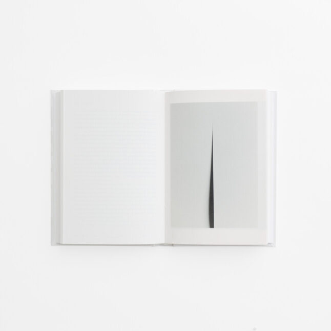 An open spread of the book 100 Whites by Hara Kenya with white pages and black and white photography