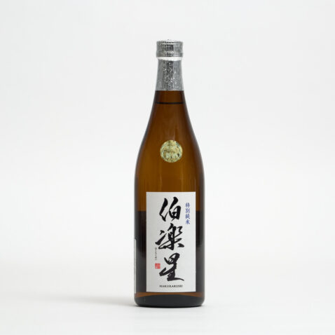 Hakurakusei Tokubetsu Junmai Sake in a brown bottle with a white label with the name written in Japanese in black