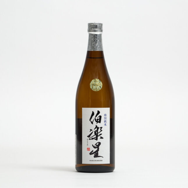 Hakurakusei Tokubetsu Junmai Sake in a brown bottle with a white label with the name written in Japanese in black