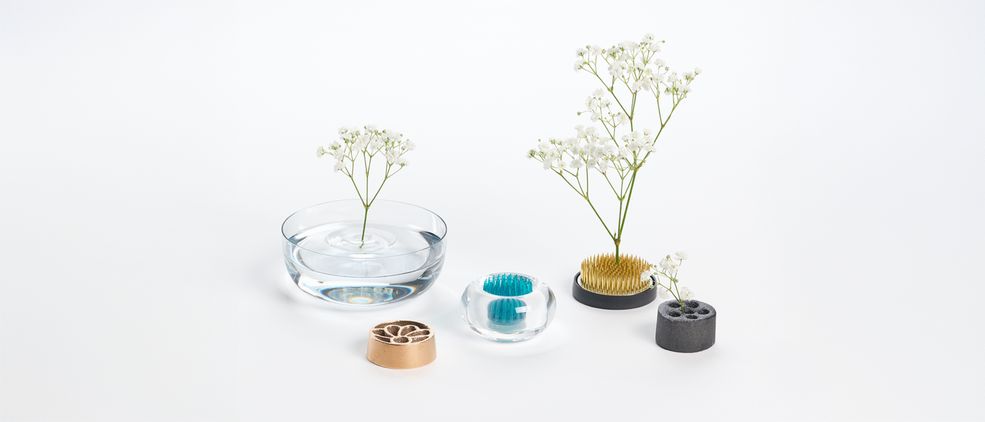A collection of kenzan, flower frogs made with glass, metal, plastic and bamboo charcoal