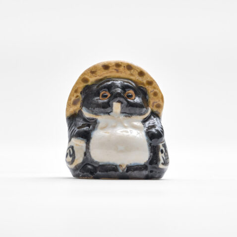 A male Shigaraki-yaki Tanuki holds a tokkuri (sake bottle), a play on the term toku (virtue), and a ledger representing trust