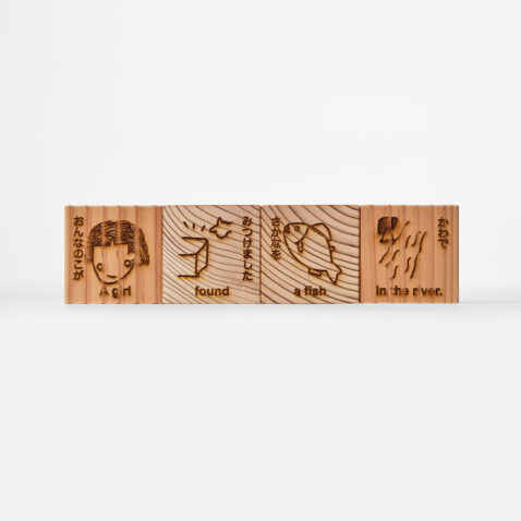 Four Moku Moku Wooden Learning Blocks, one with a picture of a girl, one with 'found', one with a picture of a fish, and one with 'in a river'