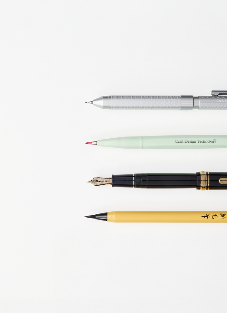 A row of four writing utensils, a brush pen, a Sailor fountain pen, a Pentel brush pen and mechanical pencil from Japan House London