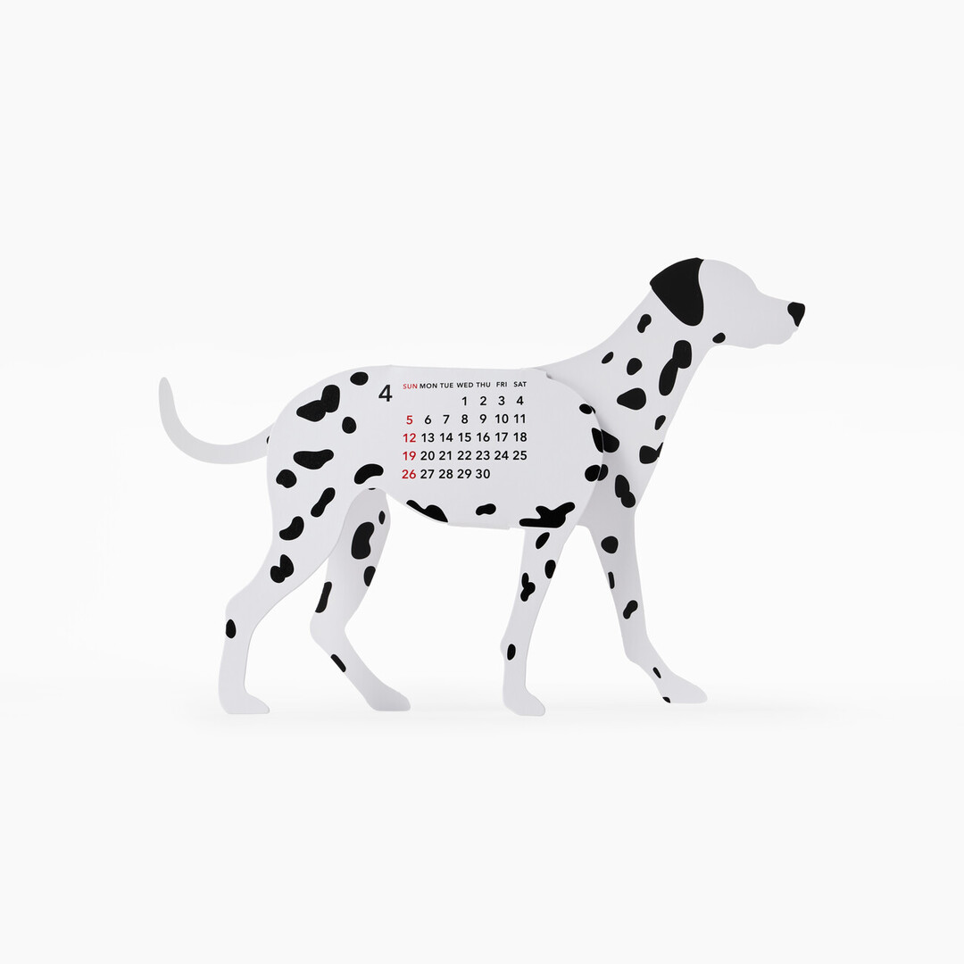 A paper calendar in the shape of a Dalmatian, showing March on the side of the days of April on the body from Japan House London