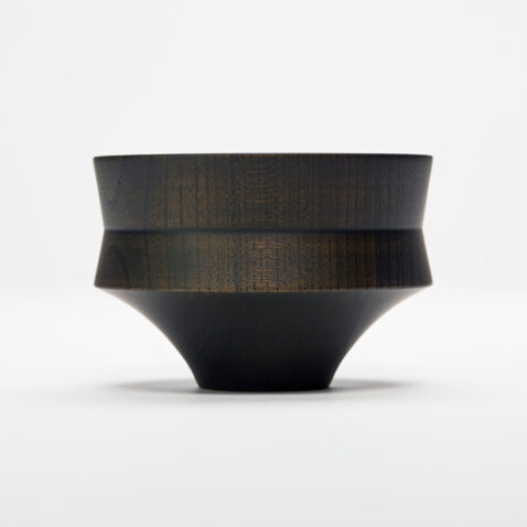 A black hand turned wooden bowl shaped like a mallet