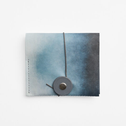 Paper wallet in Nijimi Blue, a dark blue bleeding into a lighter blue with string and washer from Japan House London.