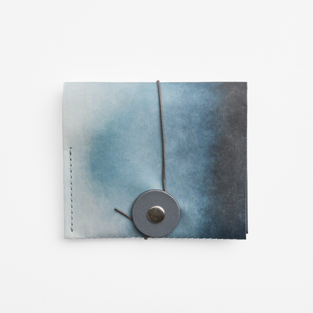 Paper wallet in Nijimi Blue, a dark blue bleeding into a lighter blue with string and washer from Japan House London.
