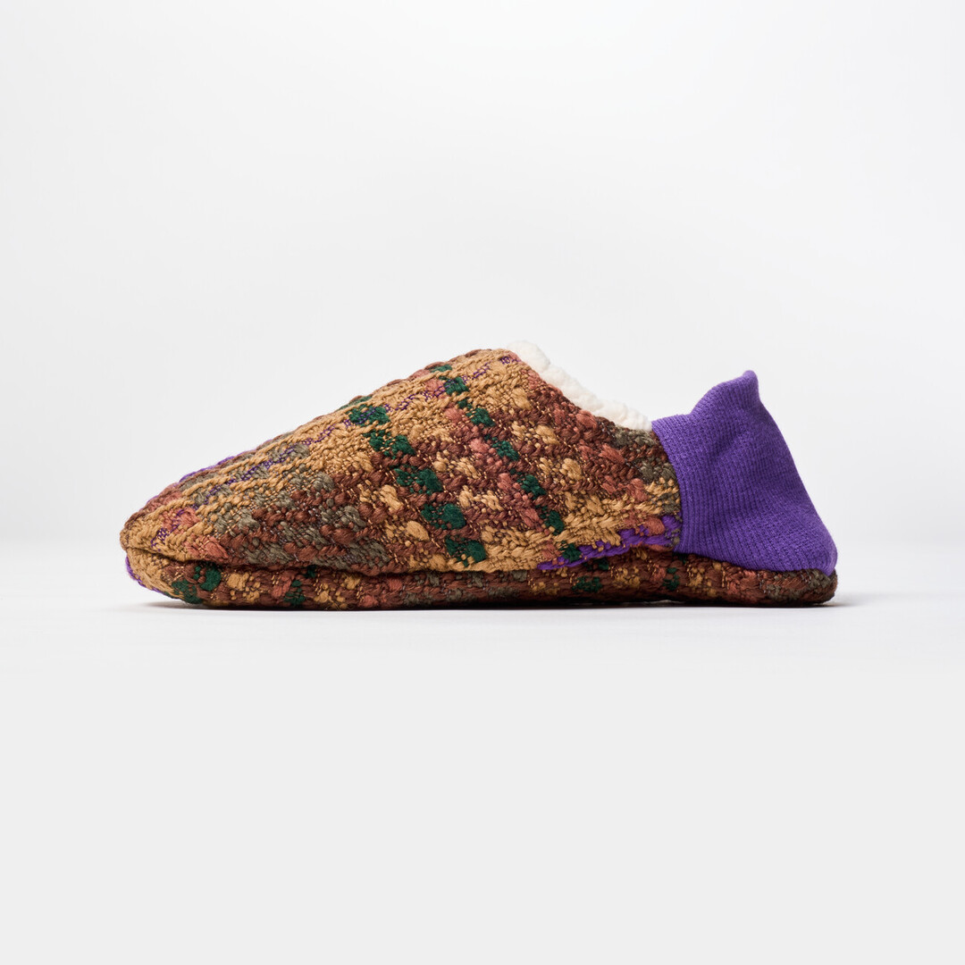 A reversible slipper with a green and brown tartan fabric with a purple ribbed heel from Japan House London.