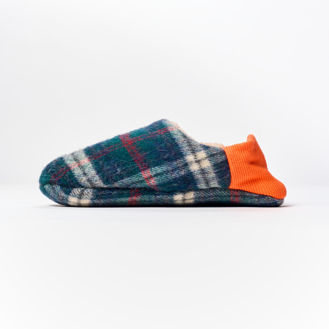 A reversible slipper with a blue and green tartan fabric with a orange ribbed heel from Japan House London.
