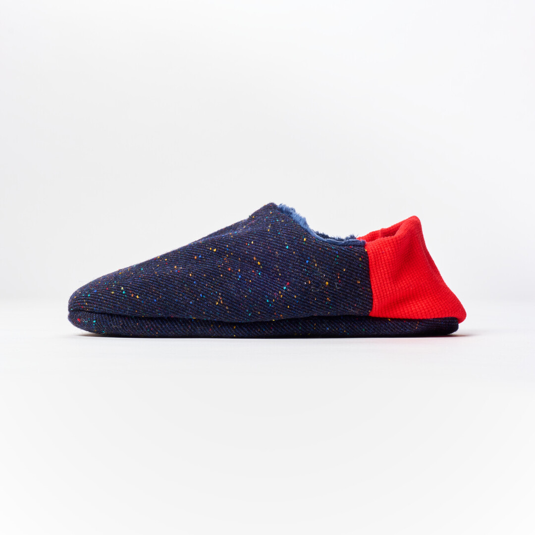 A reversible slipper with a navy blue with speckle fabric with a red ribbed heel from Japan House London.