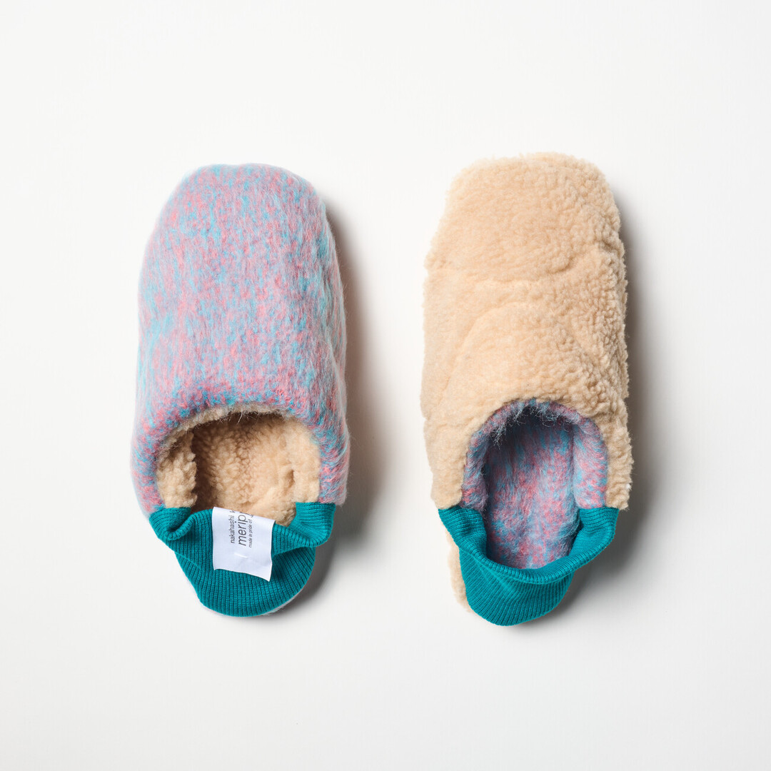A pair of reversible slippers with a felted purple and blue blended fabric and a beige shaggy fabric on the other side with a turquoise ribbed heel from Japan House London.