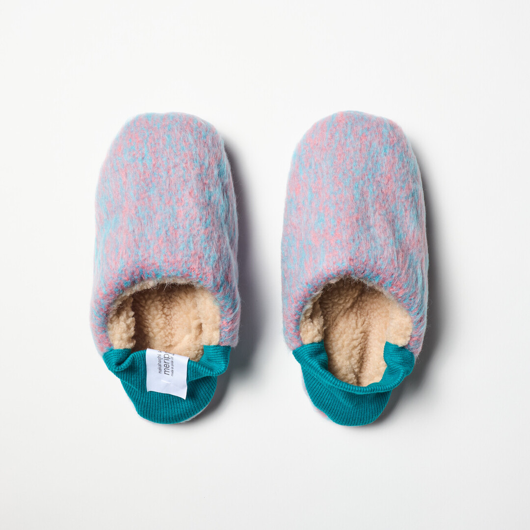 A pair of reversible slippers with a felted purple and blue blended fabric and a beige shaggy fabric on the other side with a turquoise ribbed heel from Japan House London.