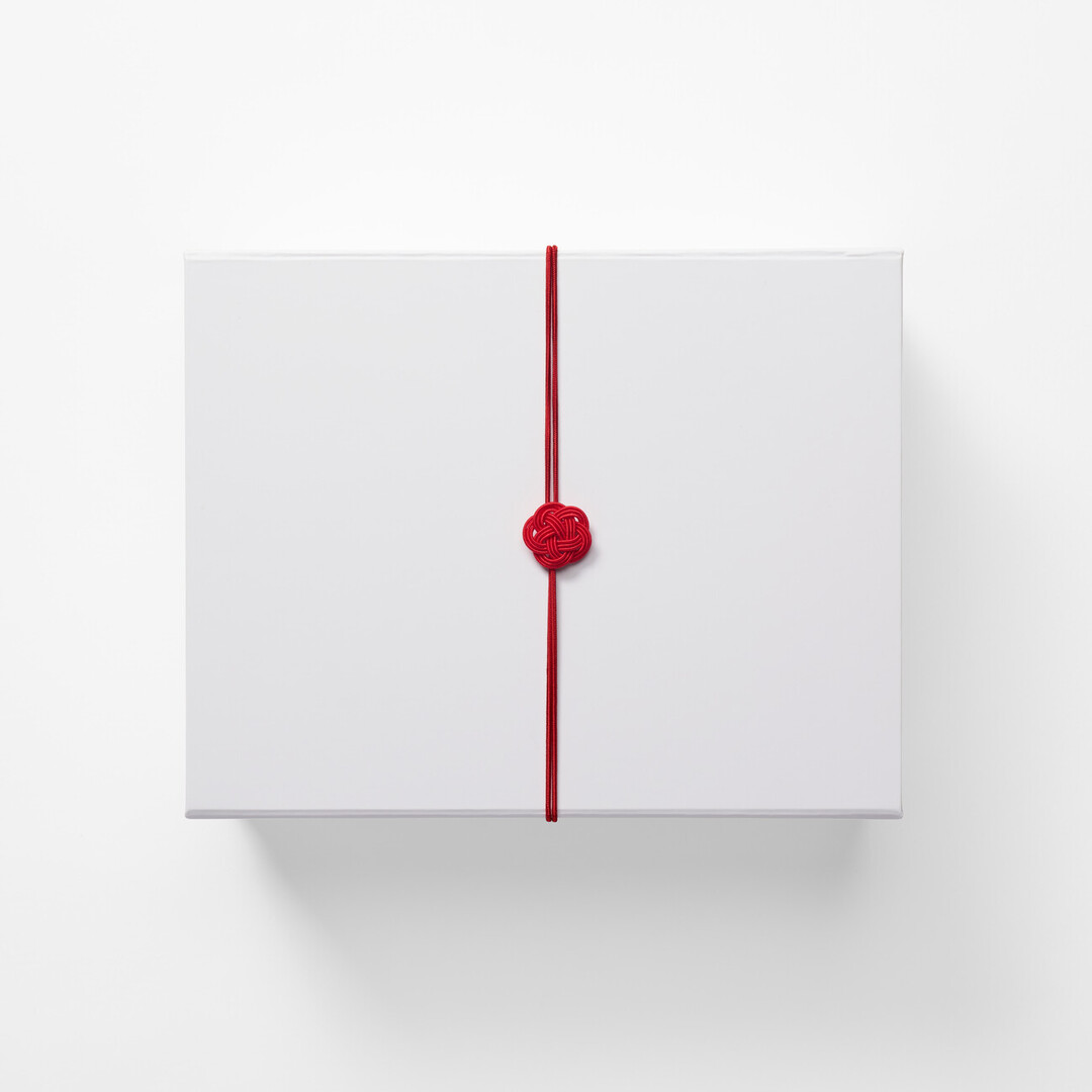 A white rectangular box with a red mizuhiki around it as a Japanese aroma gift box from Japan House London.