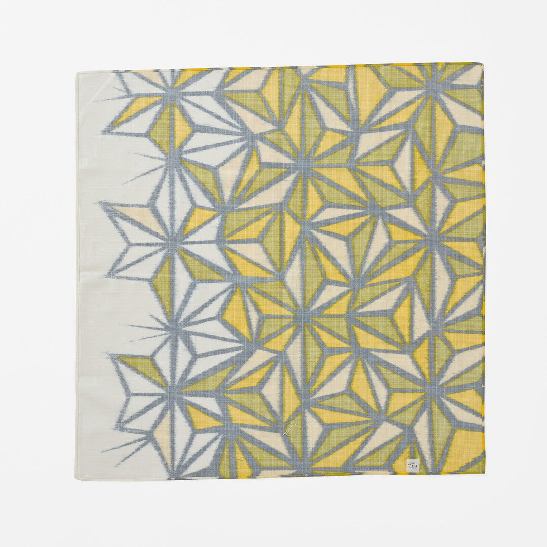 The underside of a hemp leaf design furoshiki going from white to yellow and green from Japan House London.