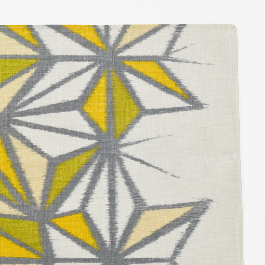 A detail of a hemp leaf design furoshiki going from white to yellow and green from Japan House London.