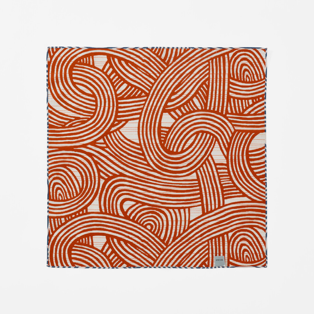 Furoshiki with a pattern of knots in orange from Japan House London.