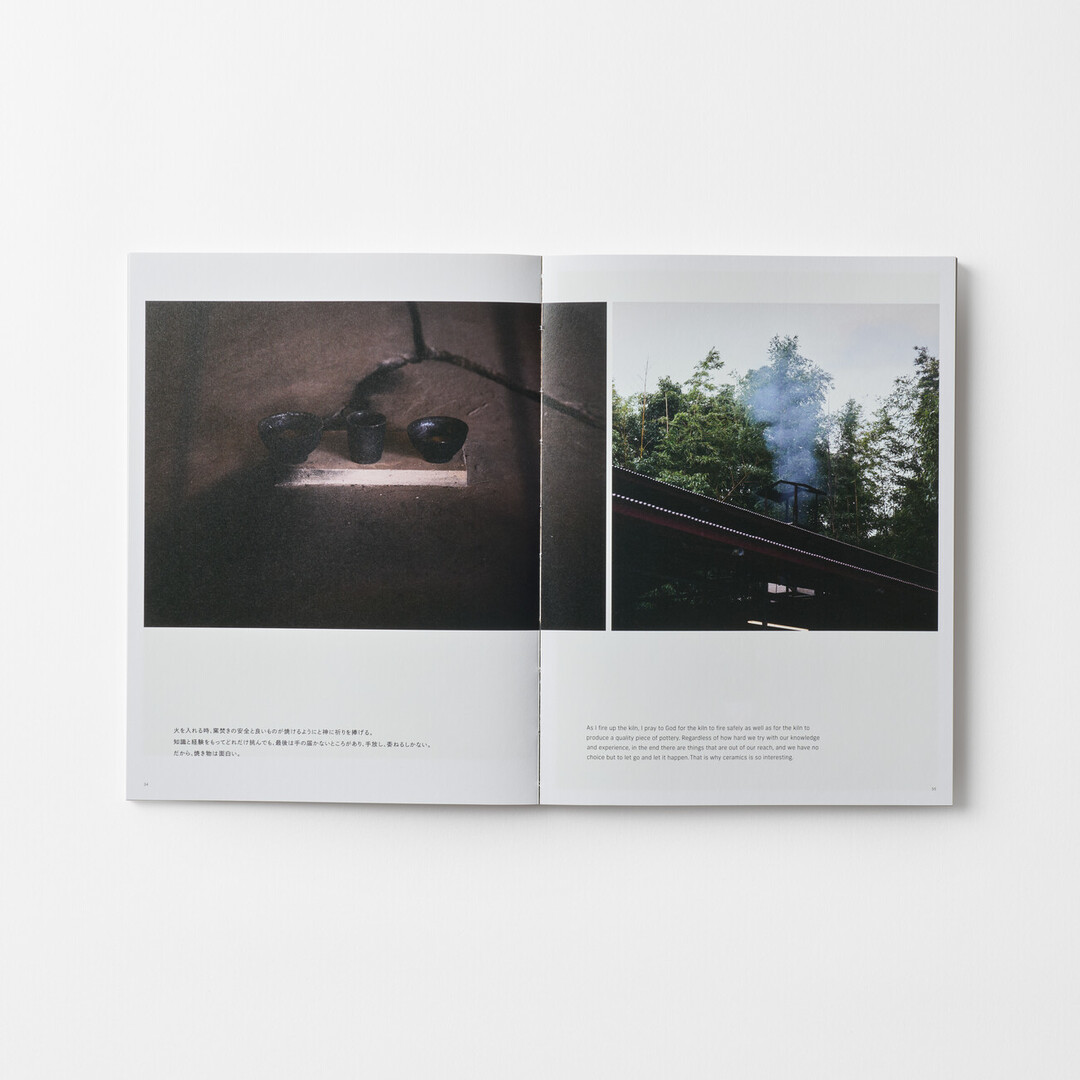 A spread of a book of HATTA TORU Ceramics with a photograph of a three black bowls and a kiln from Japan House London.