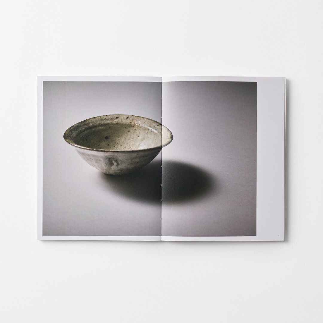 A spread of a book of HATTA TORU Ceramics with a photograph of a white bowl from Japan House London.