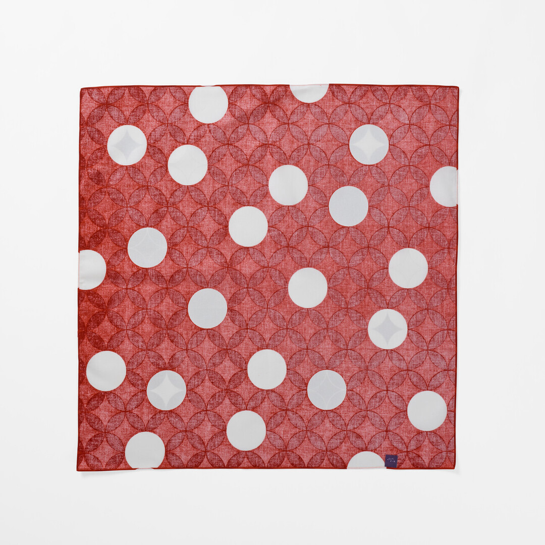 The underside of Furoshiki Seven Treasures with a red background and white circles from Japan House London.