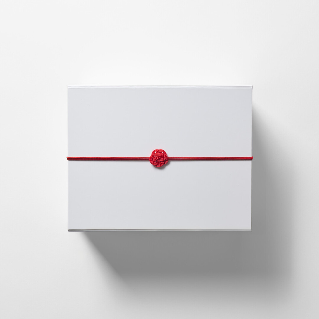 A small white gift box with a red mizuhiki from Japan House London.