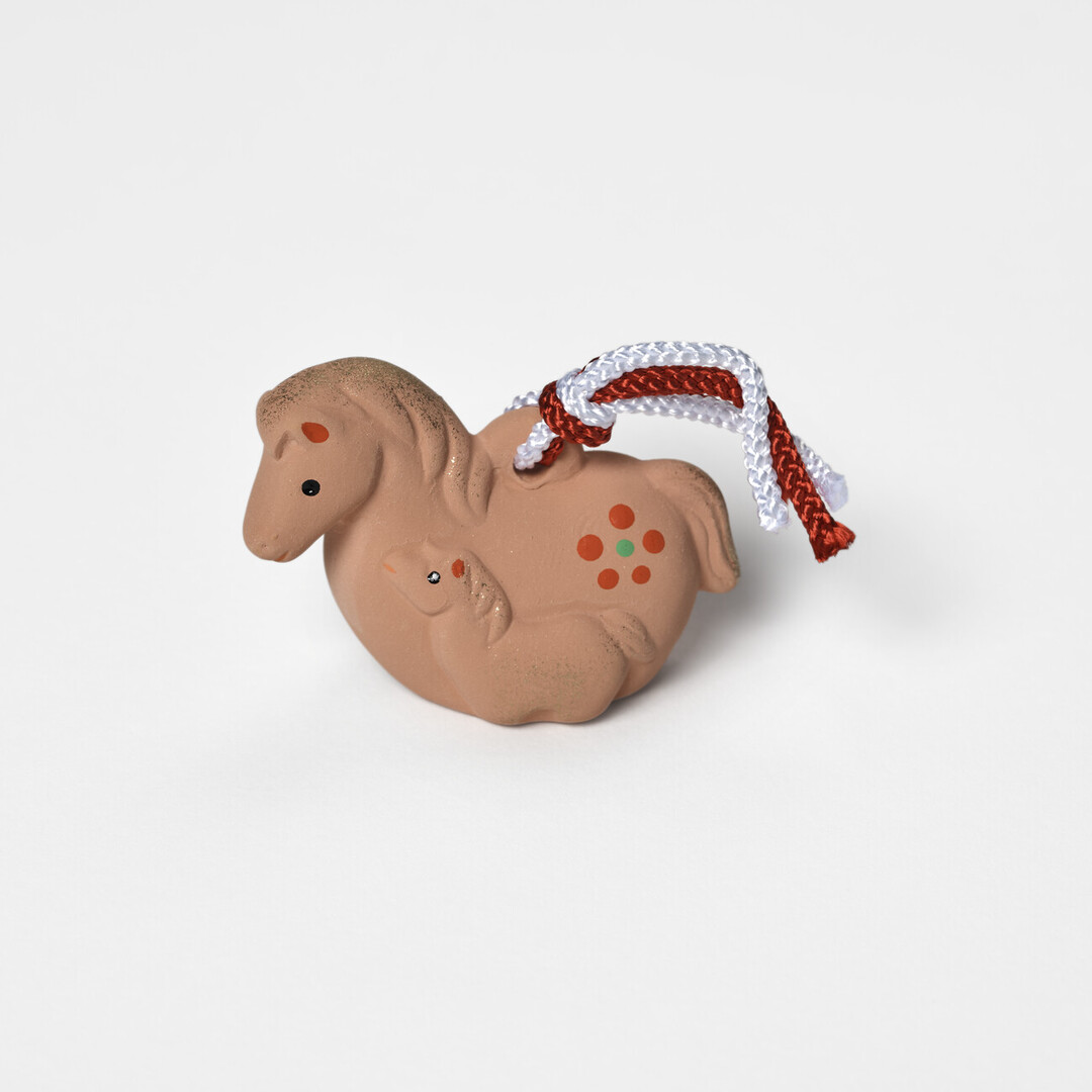 An earthenware bell in the shape of a mare and foal by Kyugetsu from Japan House London.