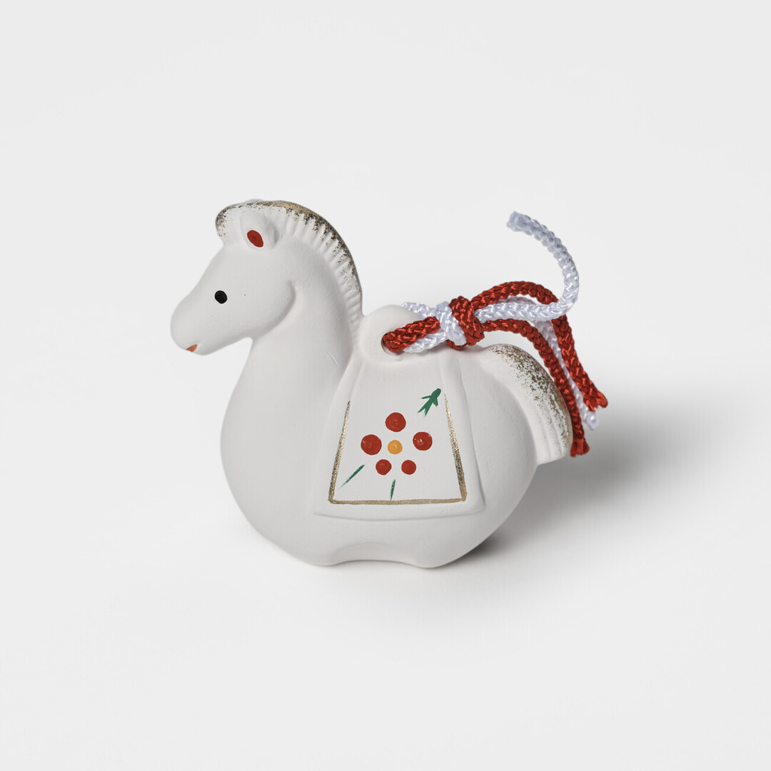 An earthenware bell in the shape of a white horse by Kyugetsu from Japan House London.