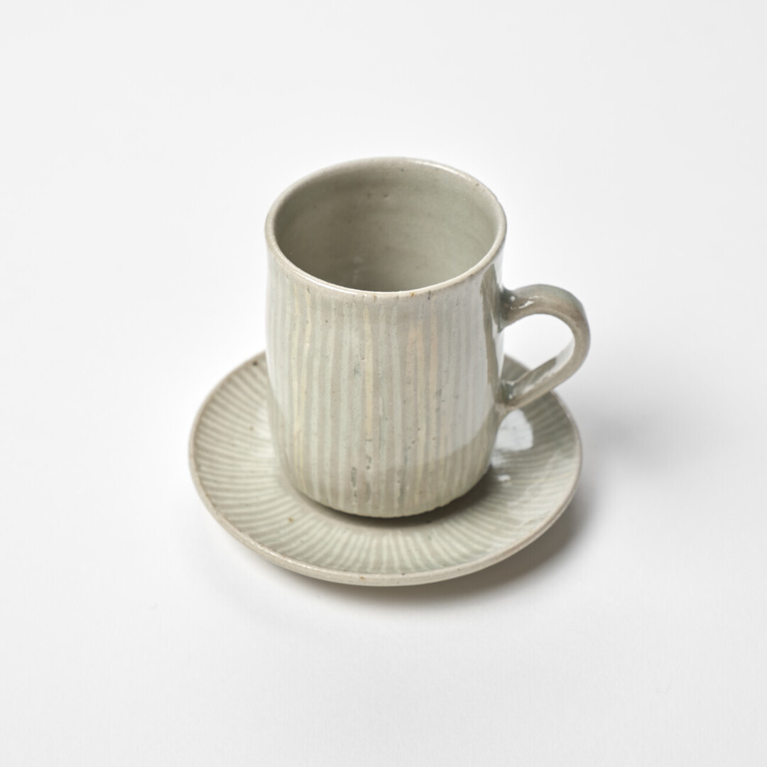Small ceramic cup and saucer with white stripes by Hidaka Shinji from Japan House London.