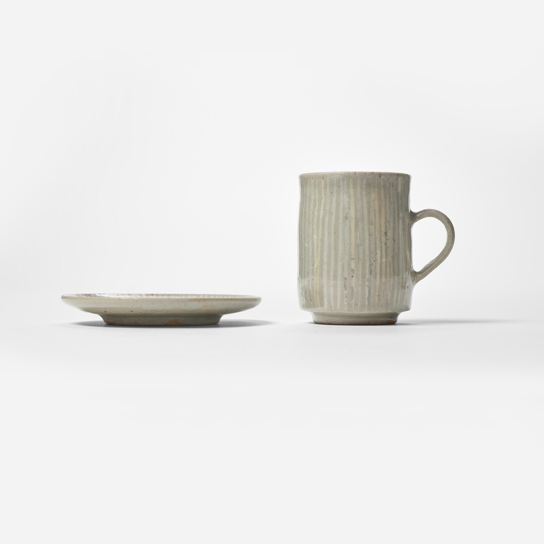 Small ceramic cup and saucer with white stripes by Hidaka Shinji from Japan House London.