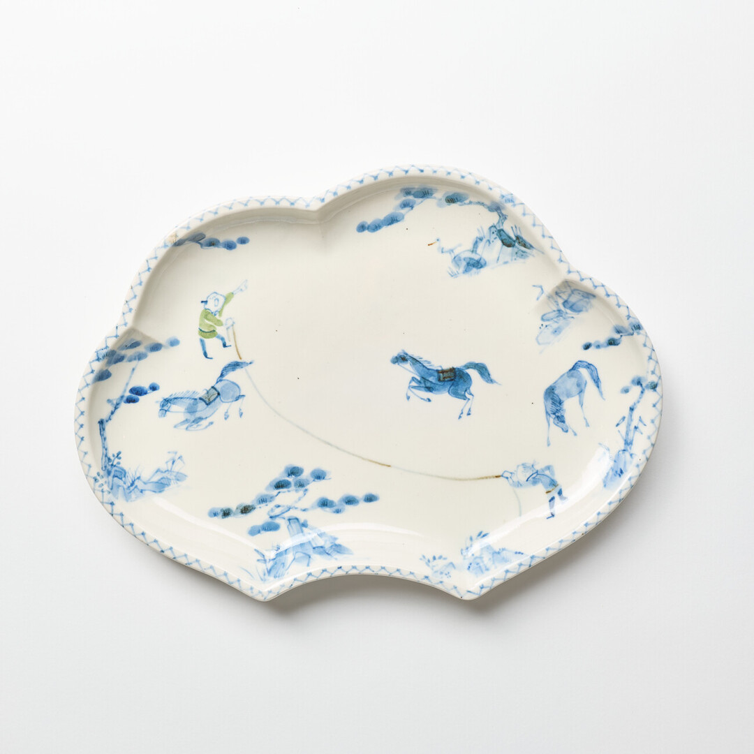 A cloud shaped plate with illustration of horses in blue by Hidaka Naoko from Japan House London.