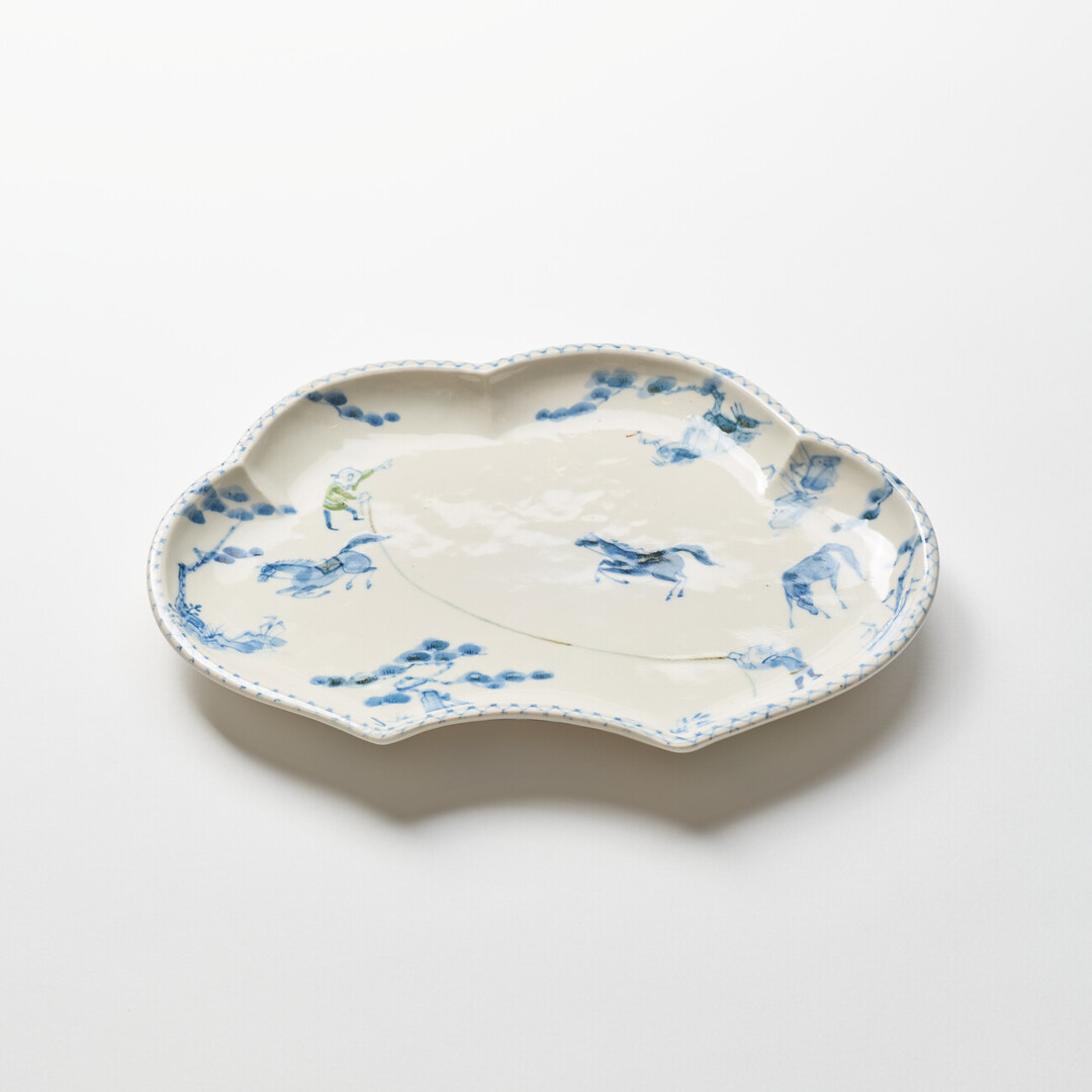A cloud shaped plate with illustration of horses in blue by Hidaka Naoko from Japan House London.