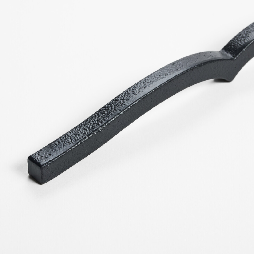 A black cast iron metal paperweight in the shape of a book from Japan House London.